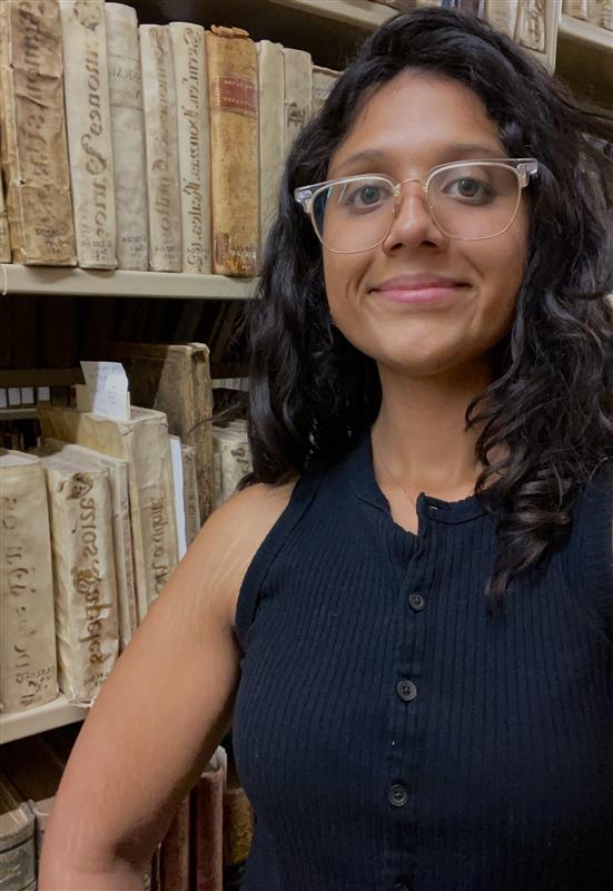 Cristina Berron standing in front of book shelf.